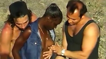 African American Lady Enjoys A Threesome With Two Caucasian Men By The Ocean